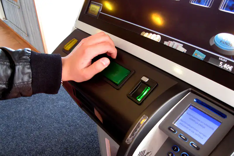 A hand pressing the buttons of a modern slot machine